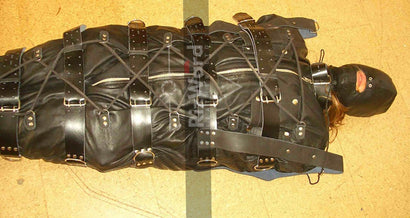 a person laying on floor wearing a leather sleep sack 